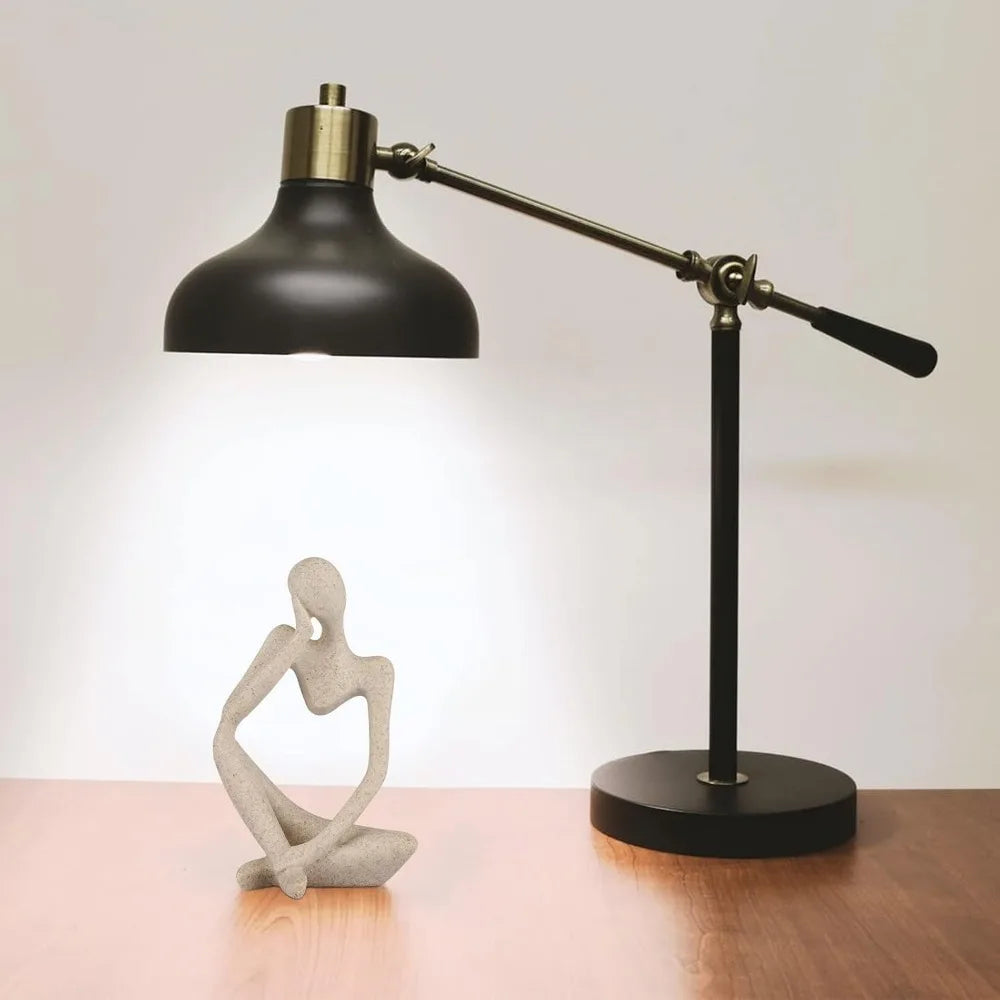 Resin thinker sculpture placed on desk with lamp – minimalist decor