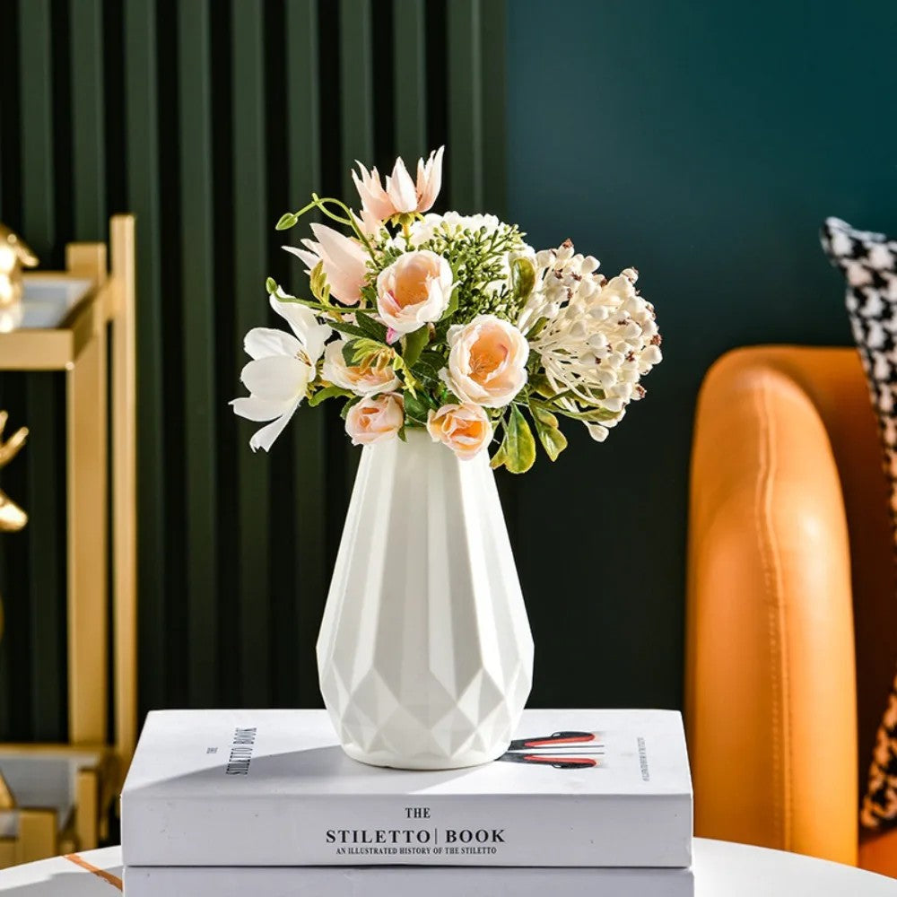 White Nordic diamond vase styled with peach and white artificial flowers on a coffee table