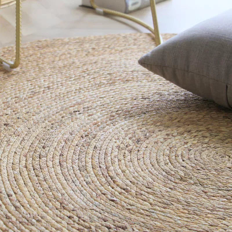 Handwoven grass carpet styled in living room near sofa and books