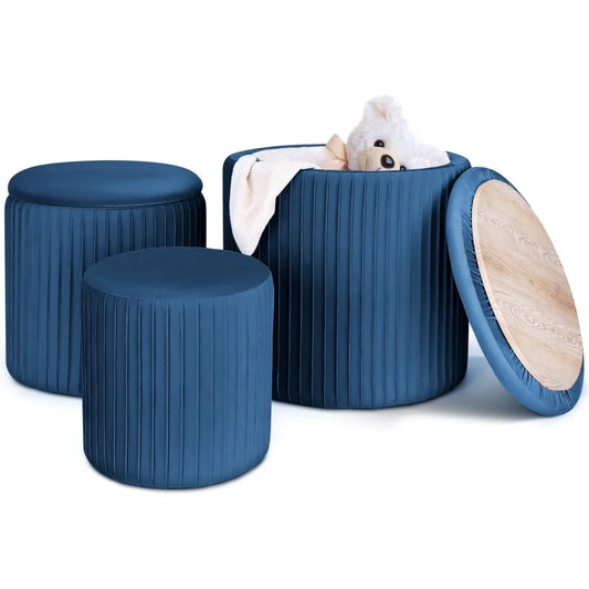 Set of 3 navy blue round velvet ottomans with one open lid showing hidden storage and toy inside