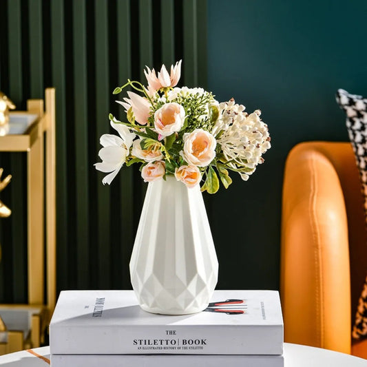 White Nordic diamond vase styled with peach and white artificial flowers on a coffee table